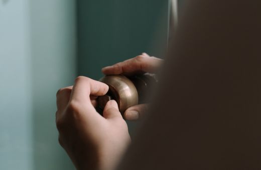 Hands fitting a pipe under a kitchen sink