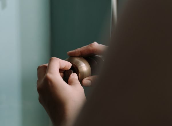 Hands fitting a pipe under a kitchen sink