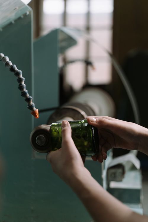 Free Close-up of hands crafting colored glass with precision tools. Captures crafting skill in a workshop. Stock Photo