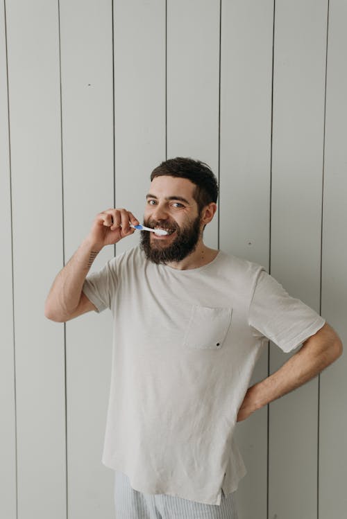 A Man Brushing Her Teeth