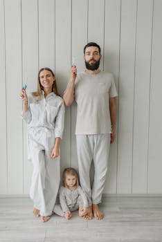 Family portrait of a couple and child in pajamas brushing teeth together for a healthy routine.