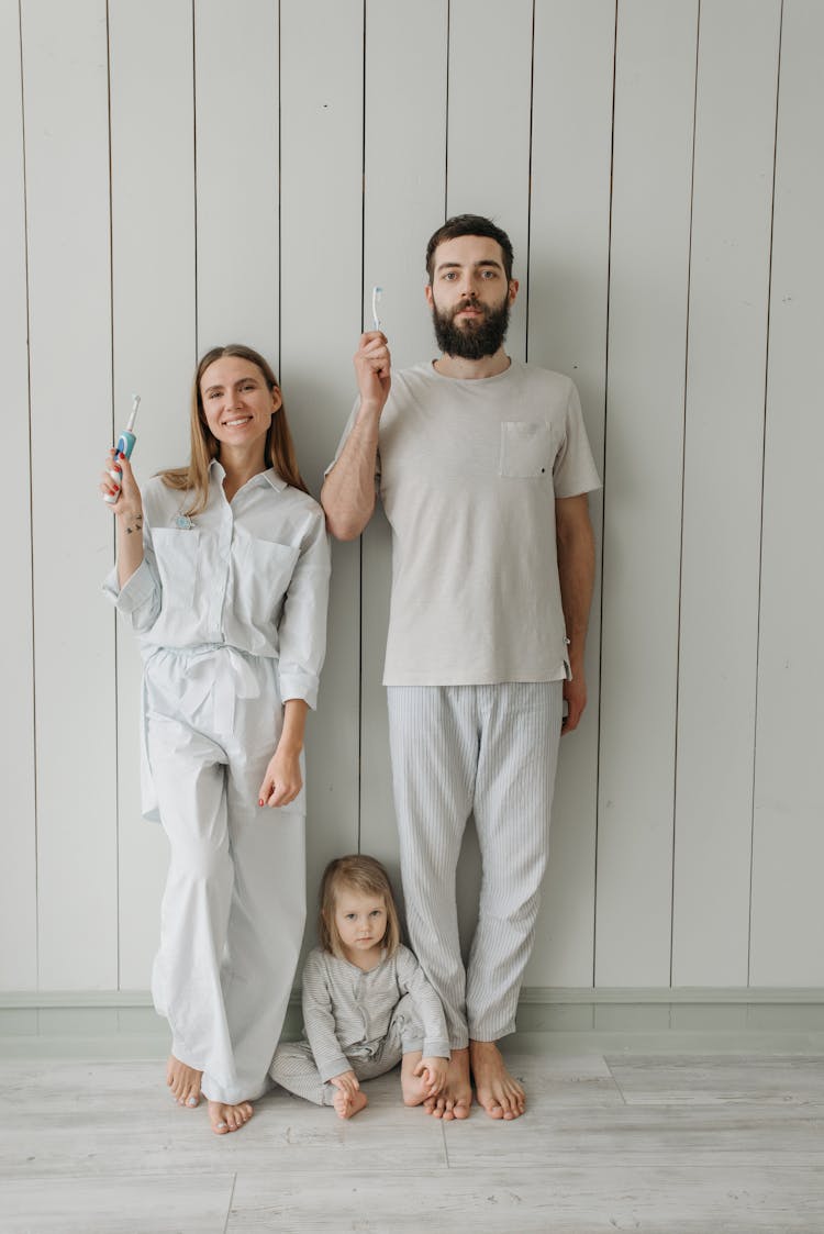 A Family Indoors Holding Toothbrush