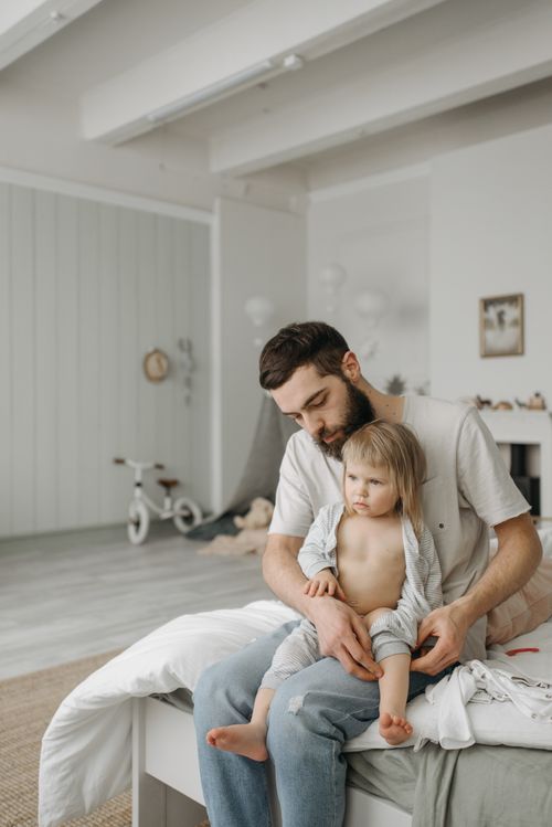 Free A father spends quality time with his toddler in a bright, cozy bedroom. Stock Photo