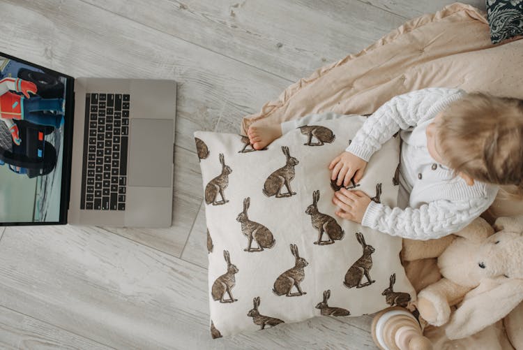 A Kid Watching A Movie On A Laptop