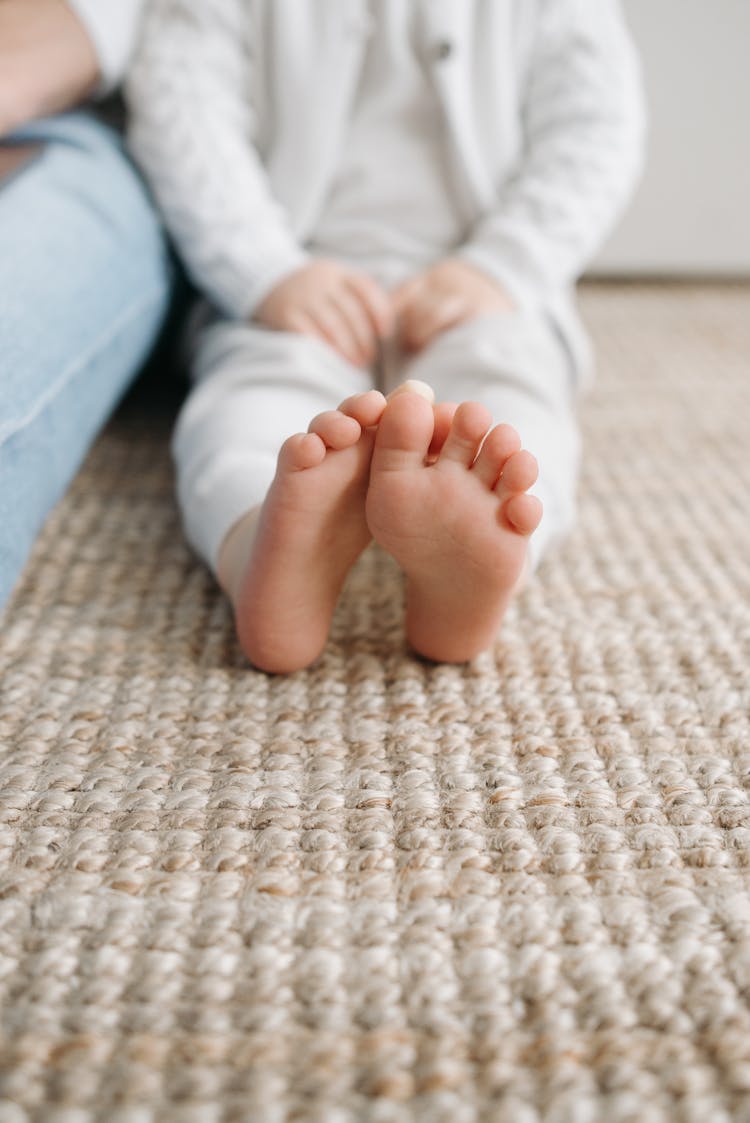 Baby's Feet On Brown Rug