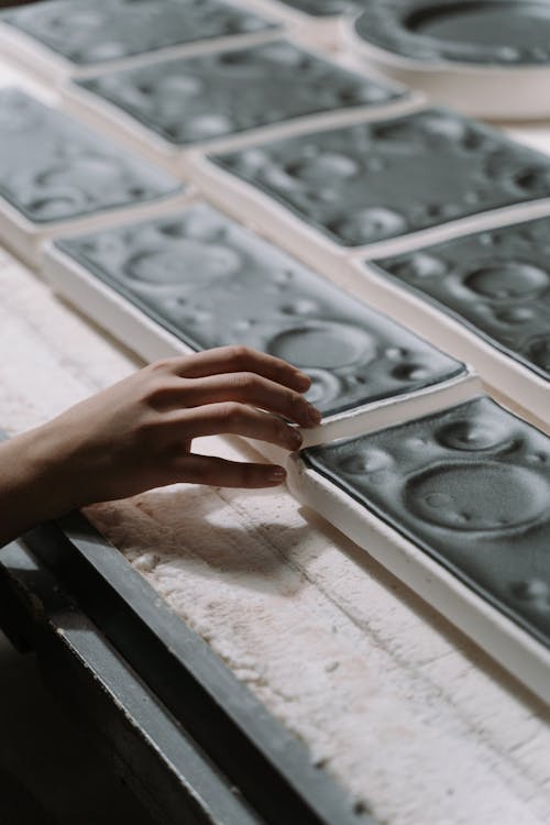 Person Touching Black Ceramic Tray