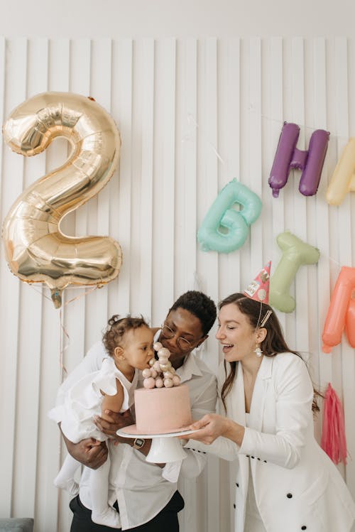 Free A Child Biting a Cake Decoration on a Birthday Cake Stock Photo