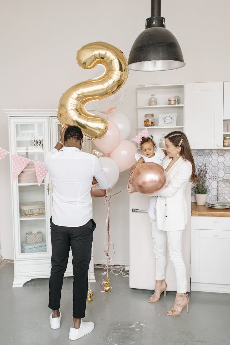 Man And Woman Holding Balloons