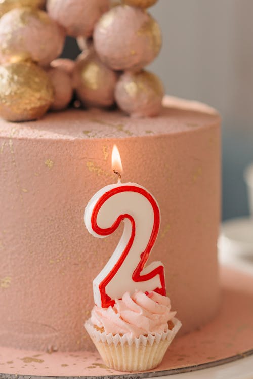 Free Lighted Candle on a Pink Cupcake Stock Photo