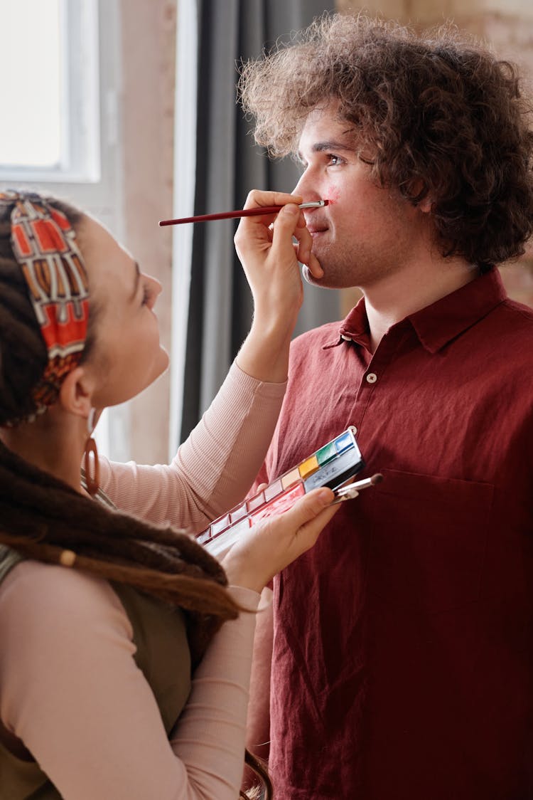 Woman Painting The Man's Face