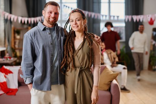 Free A diverse group of friends smiling and enjoying a cozy indoor party setting. Stock Photo