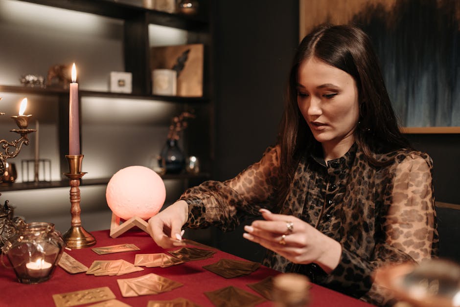 A woman performing tarot reading with candles and mystical ambiance indoors.