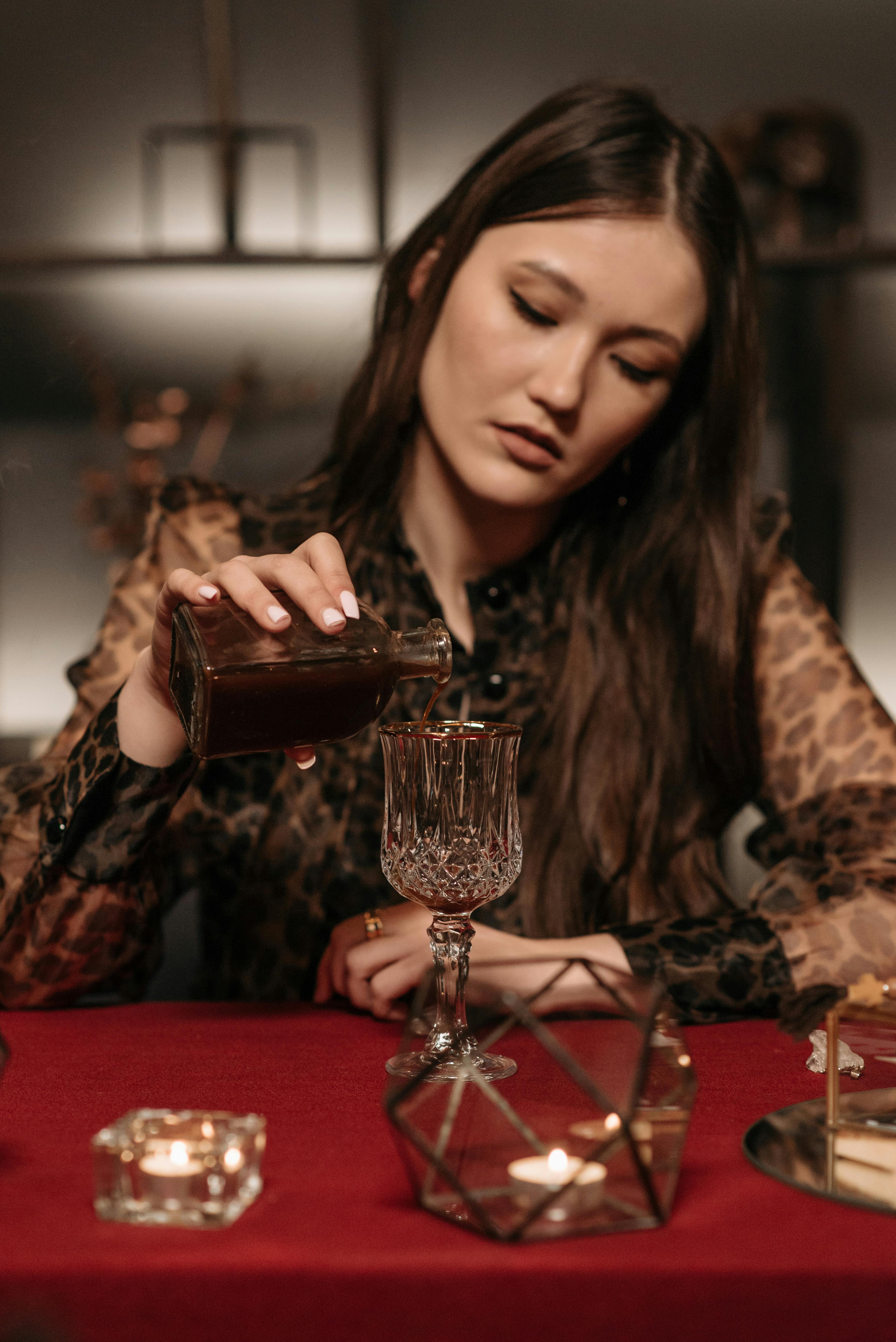 Female Fortune Teller pouring Liquid on a Wine Glass · Free Stock Photo