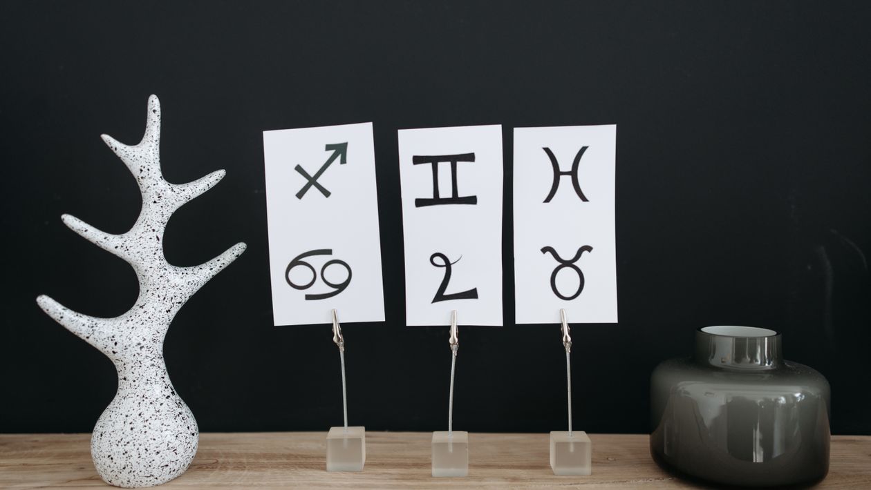 Cards displaying several zodiac sign symbols on a table.