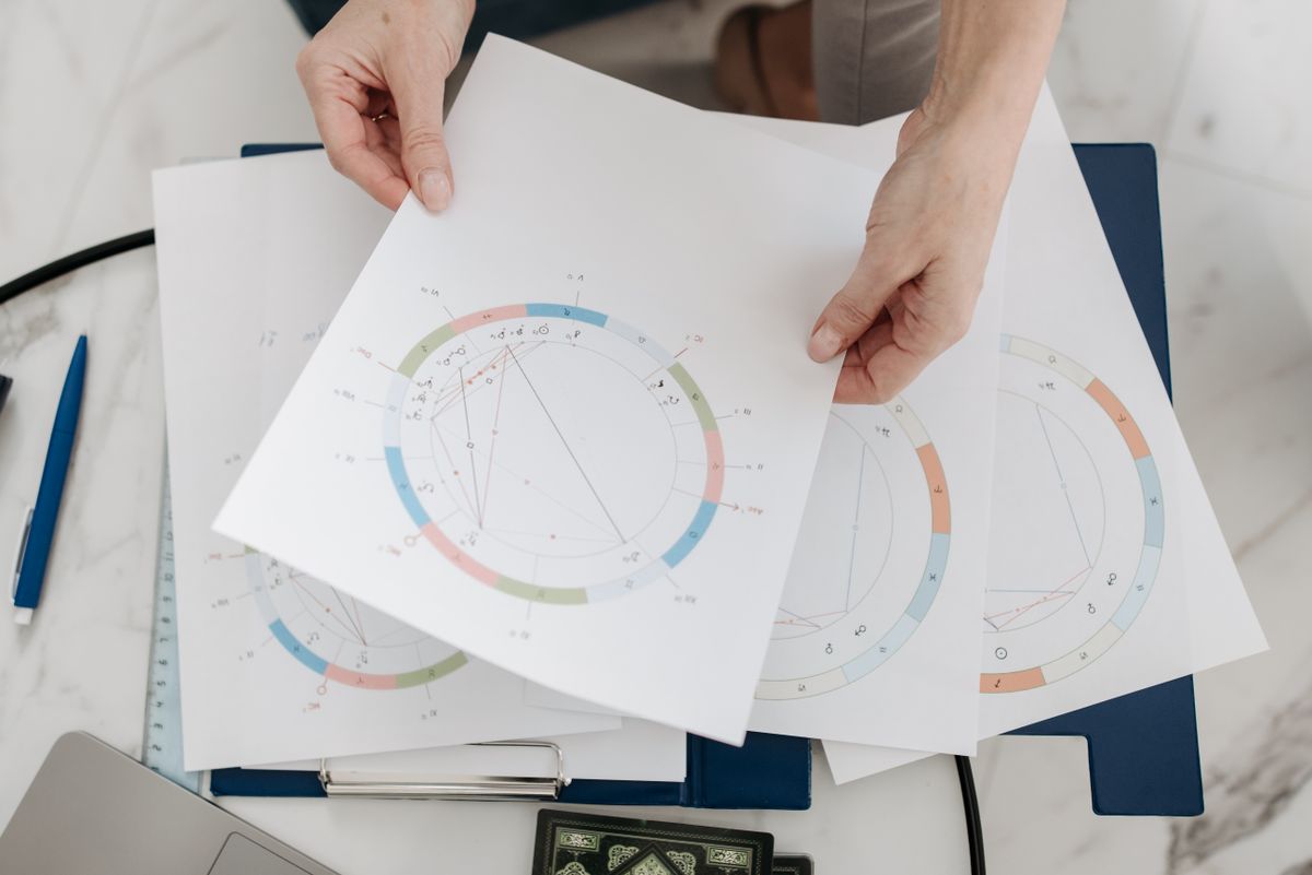 Hands holding horoscope birth chart diagrams for kundali matching