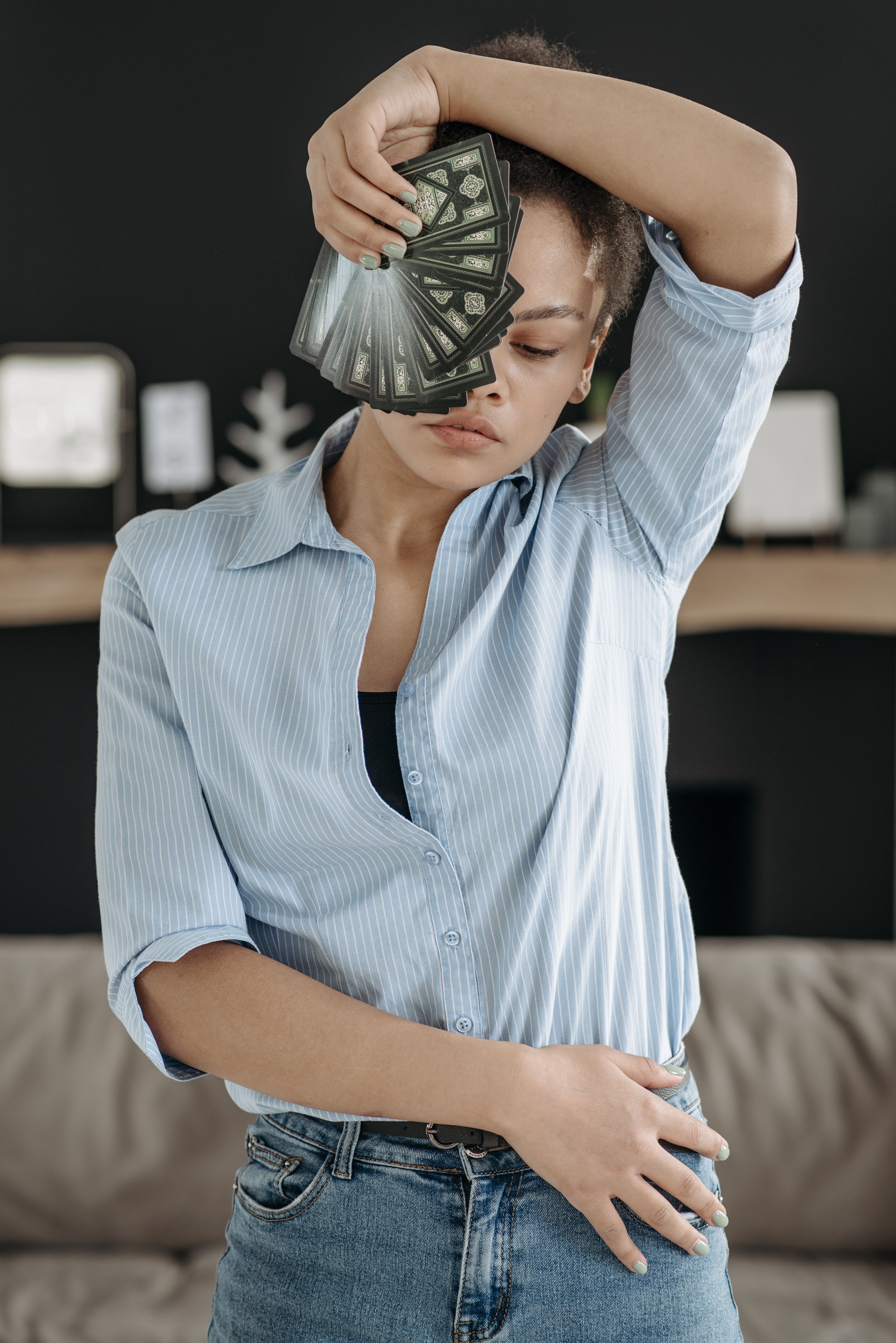 A stylish woman in a blue shirt striking a pose while holding banknotes, creating a fashion-forward look.