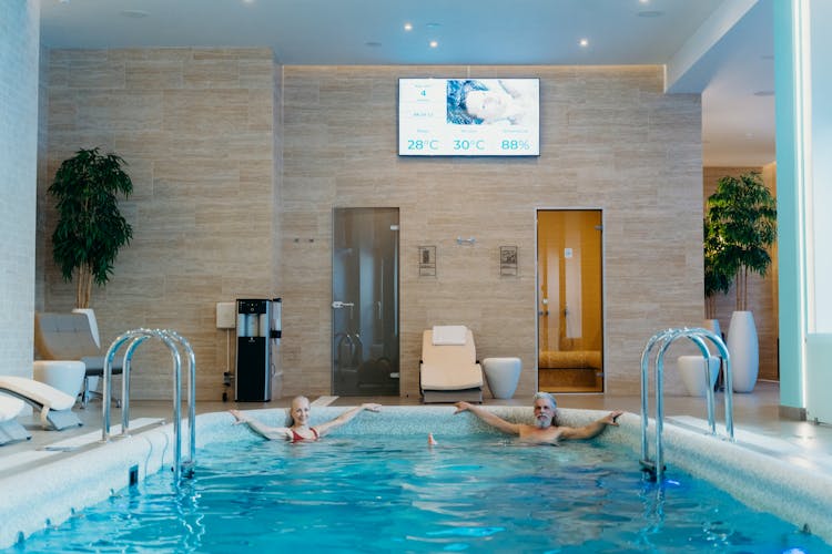 A Man And Woman Swimming In The Pool