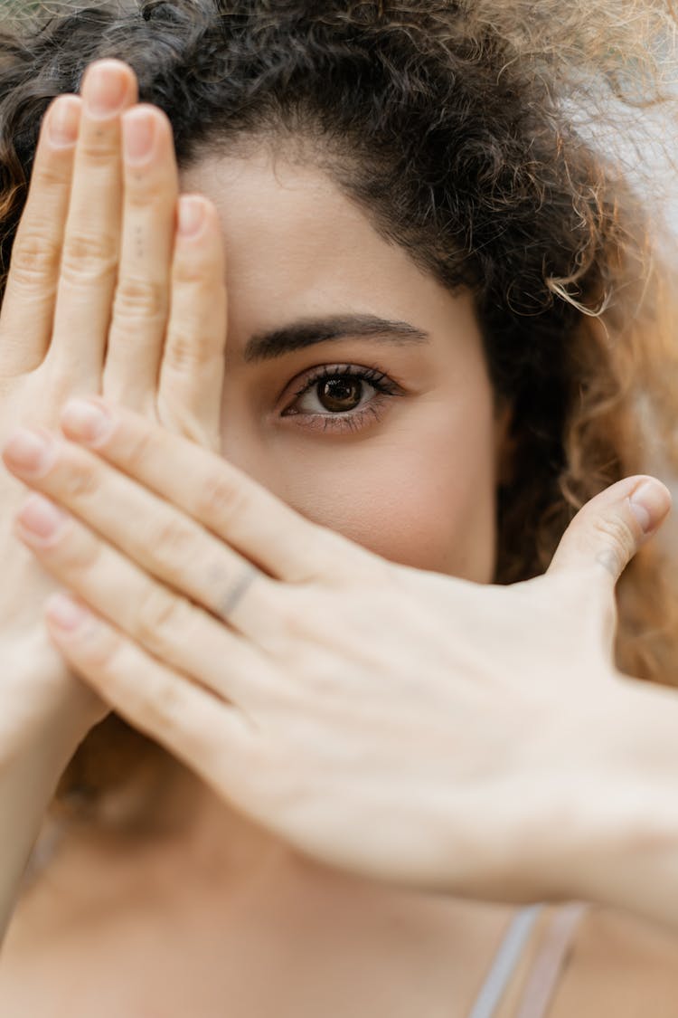 Close-up Of Woman Portrait Hands Covering Face