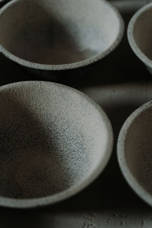 Free From above closeup of set of gray ceramic bowls placed on gray surface on daytime Stock Photo
