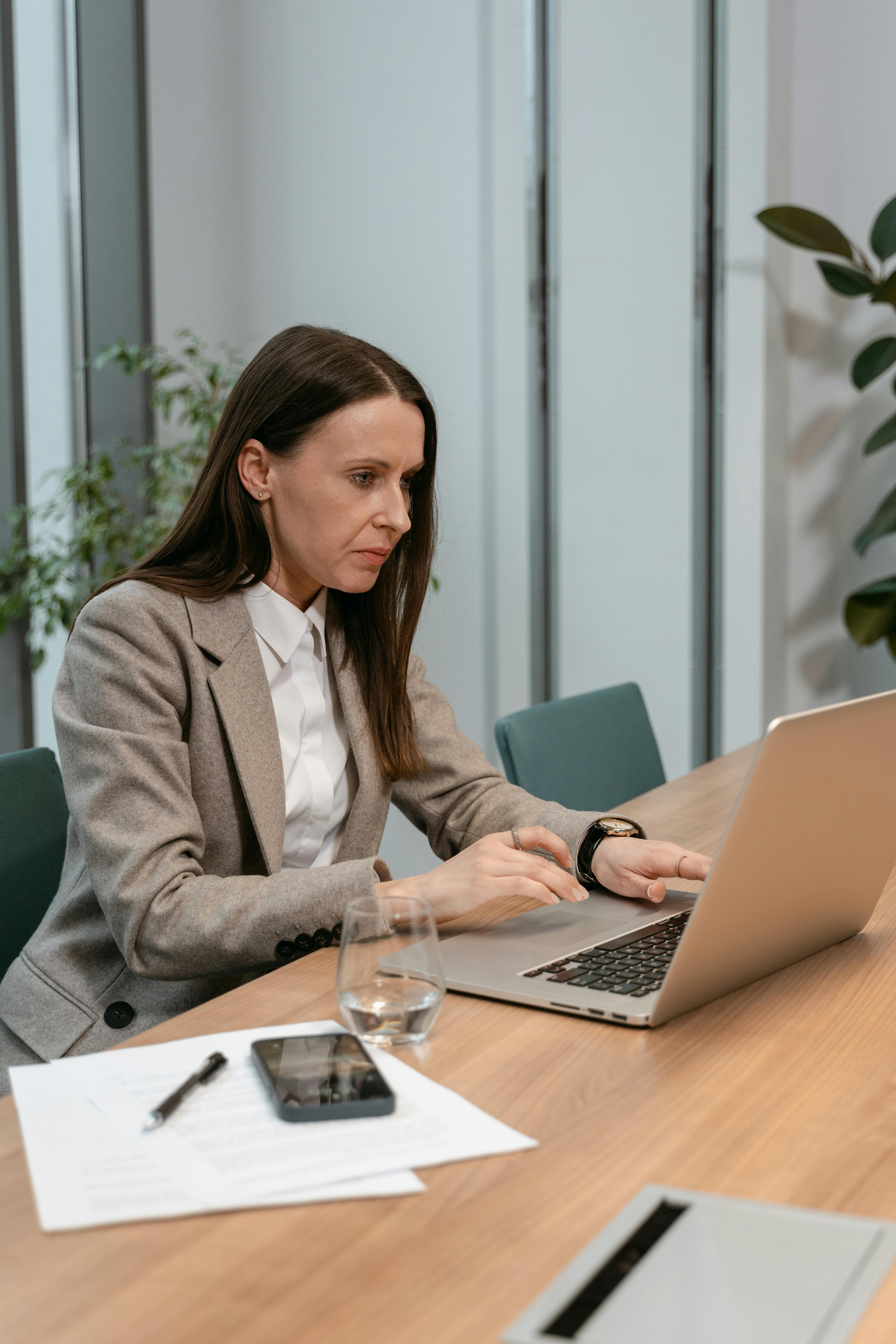B2B professional writing LinkedIn post on laptop in office