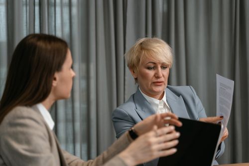 Free Two women discussing documents in a corporate meeting. Stock Photo