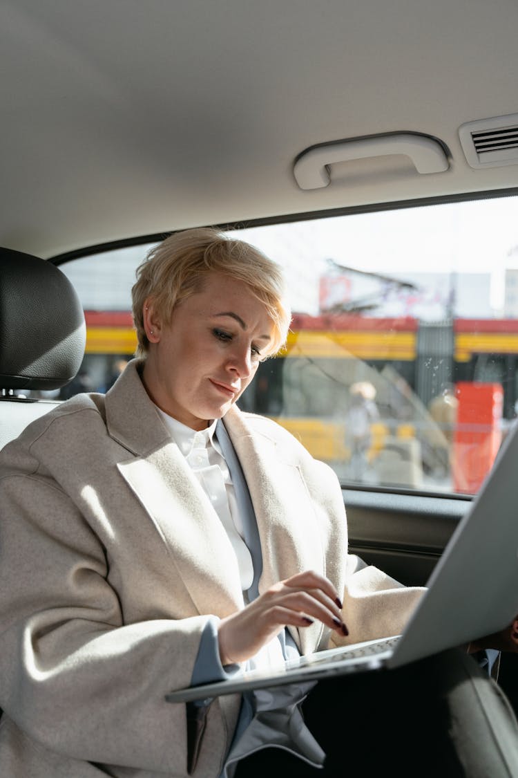 Woman In Gray Coat Sitting On Car Seat