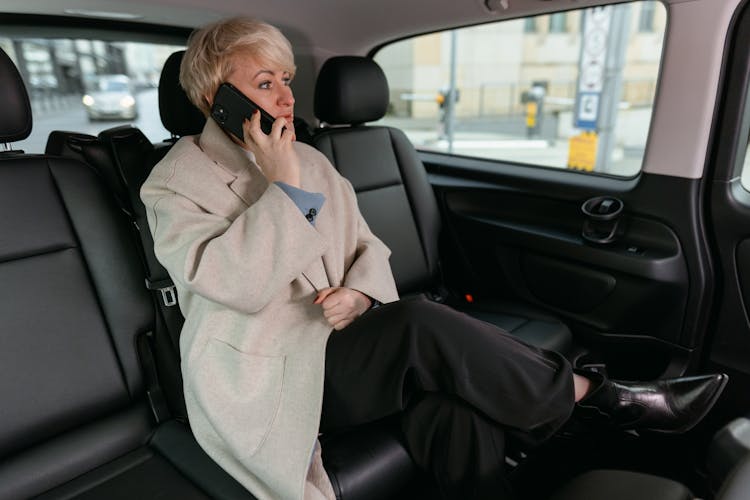 Woman In Brown Coat Sitting Inside The Car While Having A Phone Call