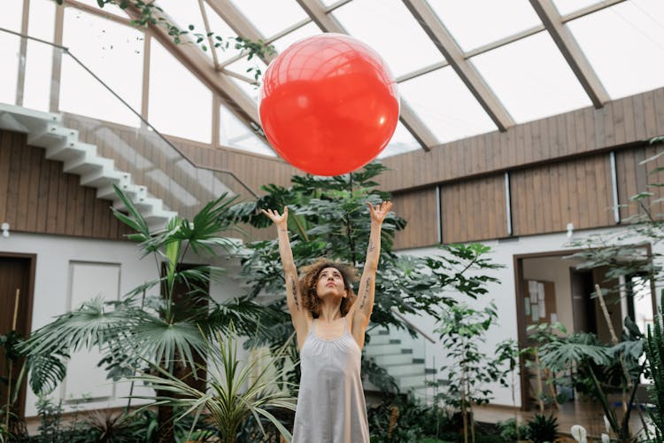 Woman Tossing A Red Ball