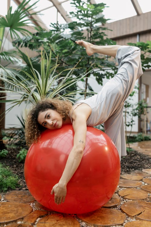 Woman Leaning on a Red Exercise Ball