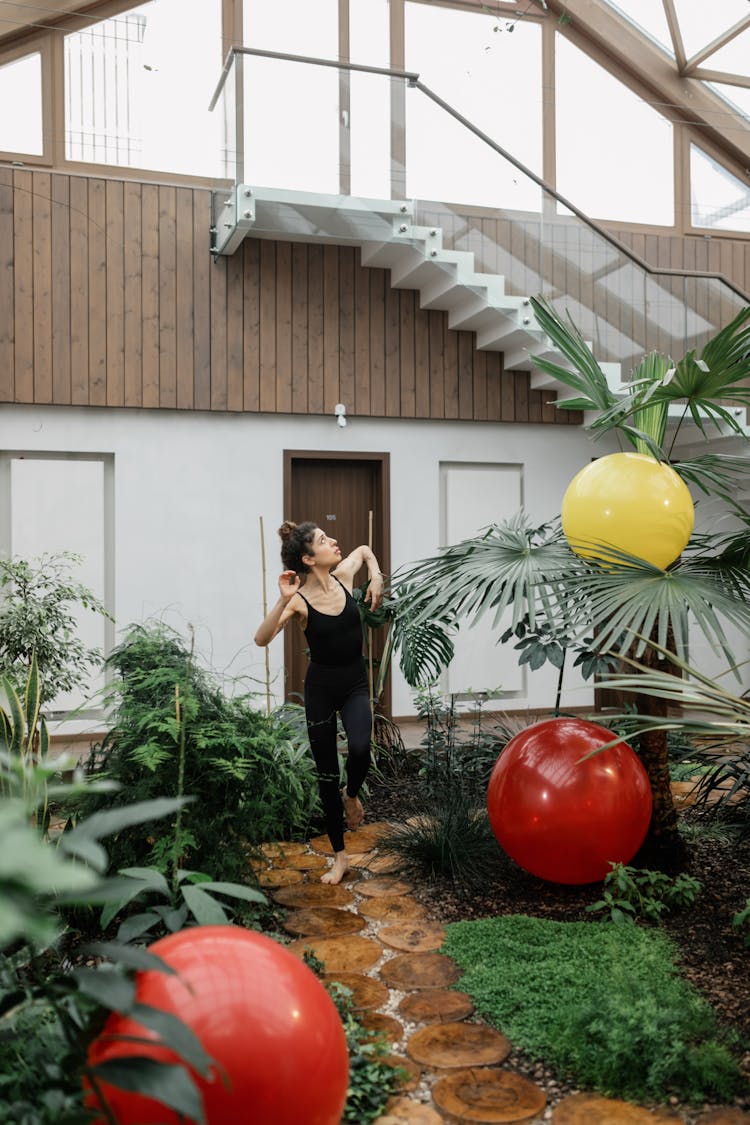 Woman Exercising At Greenhouse