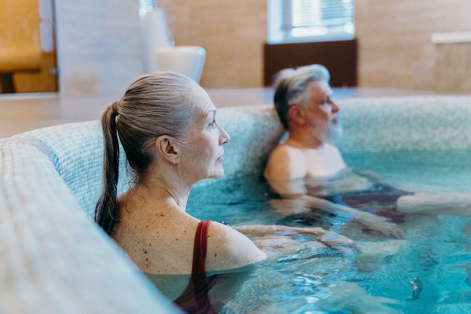 Elderly couple enjoying leisure time in an indoor swimming pool, promoting relaxation and health.