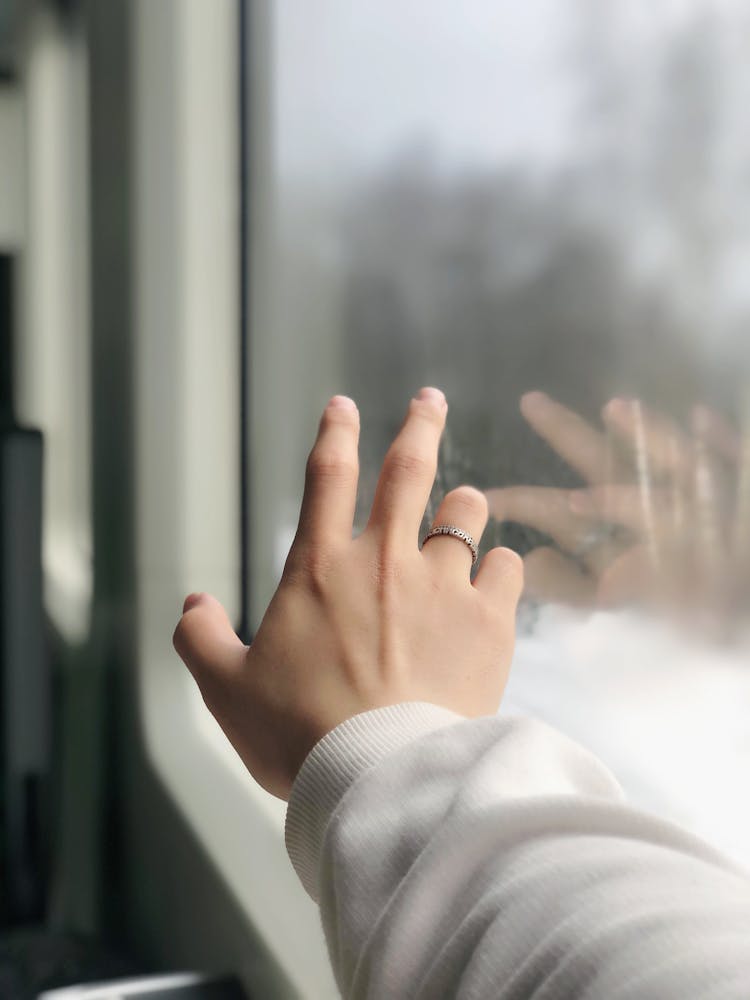 Photo Of A Person's Hand Touching A Window