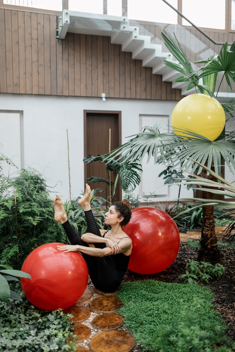 Woman Sitting On Ground With Balls