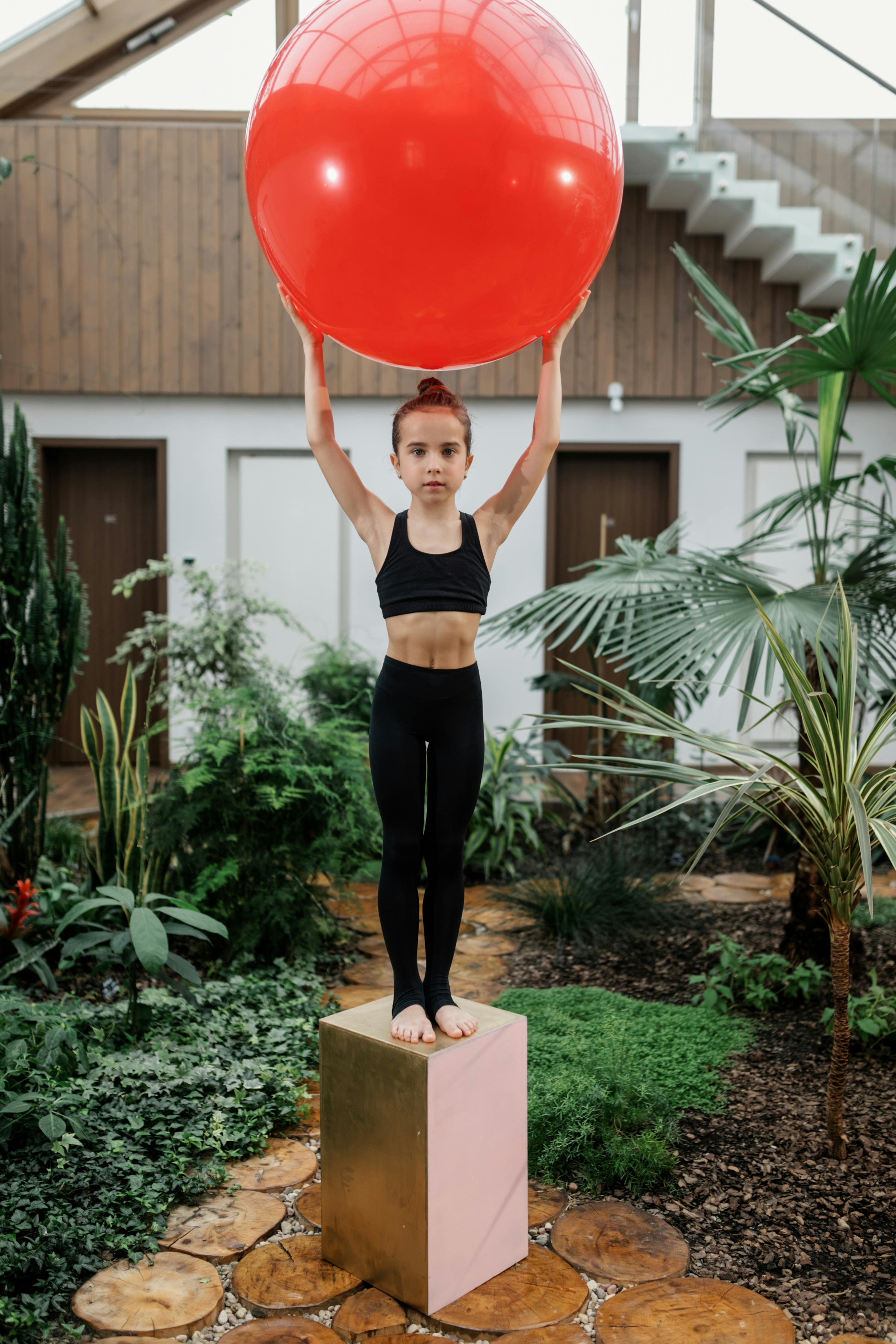 girl standing in garden holding balloon