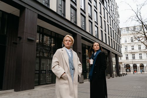 Free Man in White Coat Standing Beside Woman in Blue Dress Stock Photo