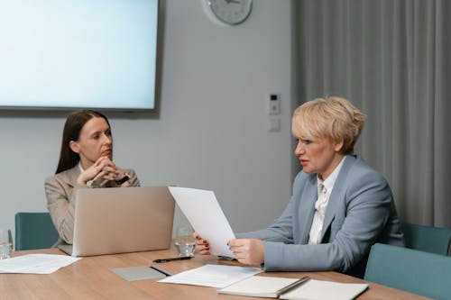 Two Women Sitting at Table with Laptop