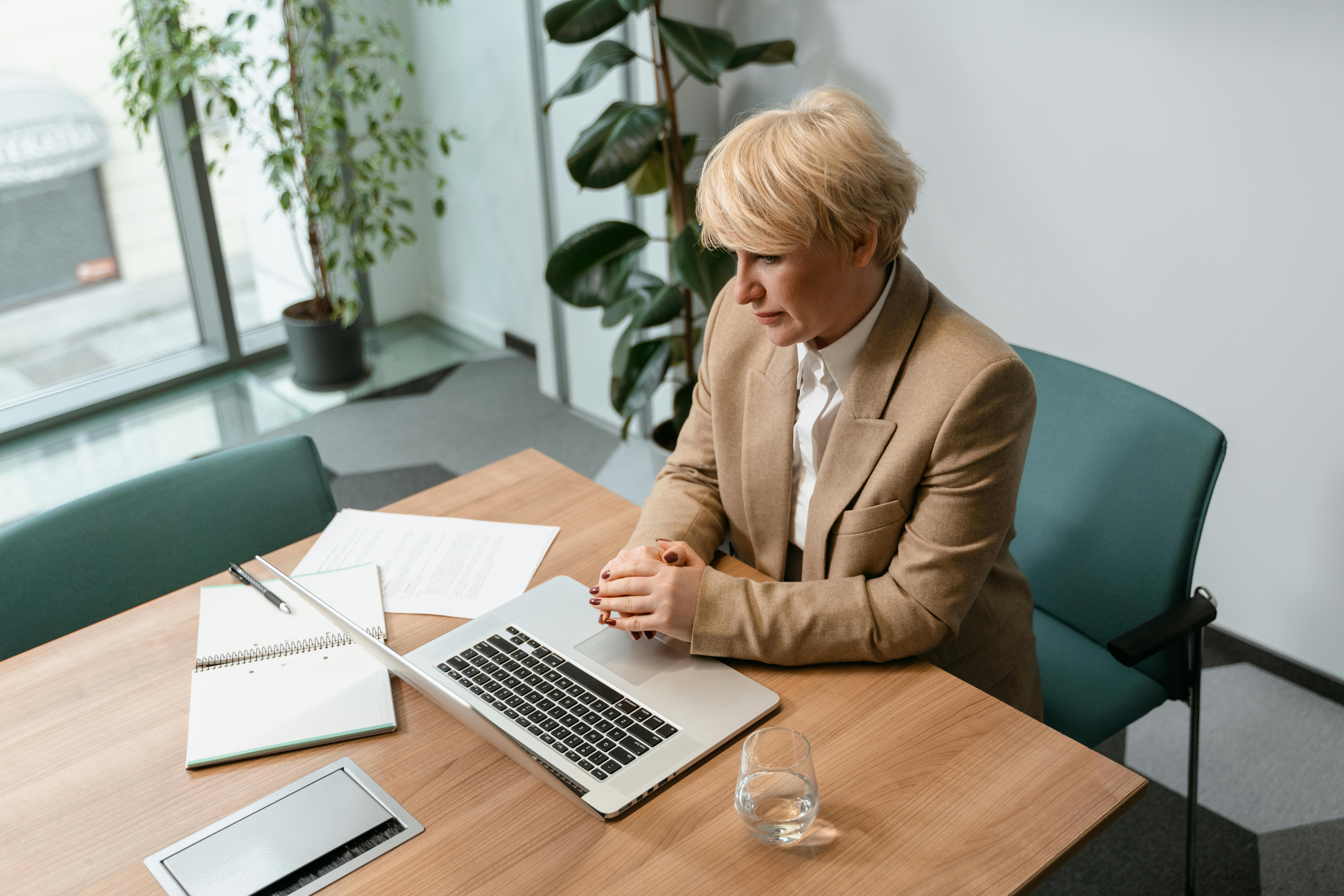 A Woman Sitting at a Desk Looking at her Computer Screen