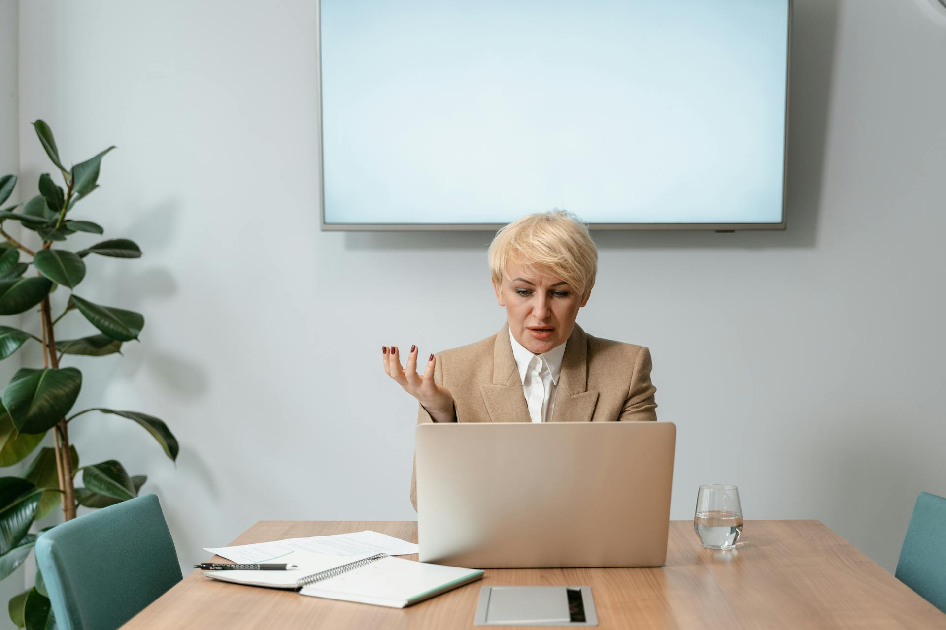 Professional businesswoman conducting a video conference call in a modern office setting.