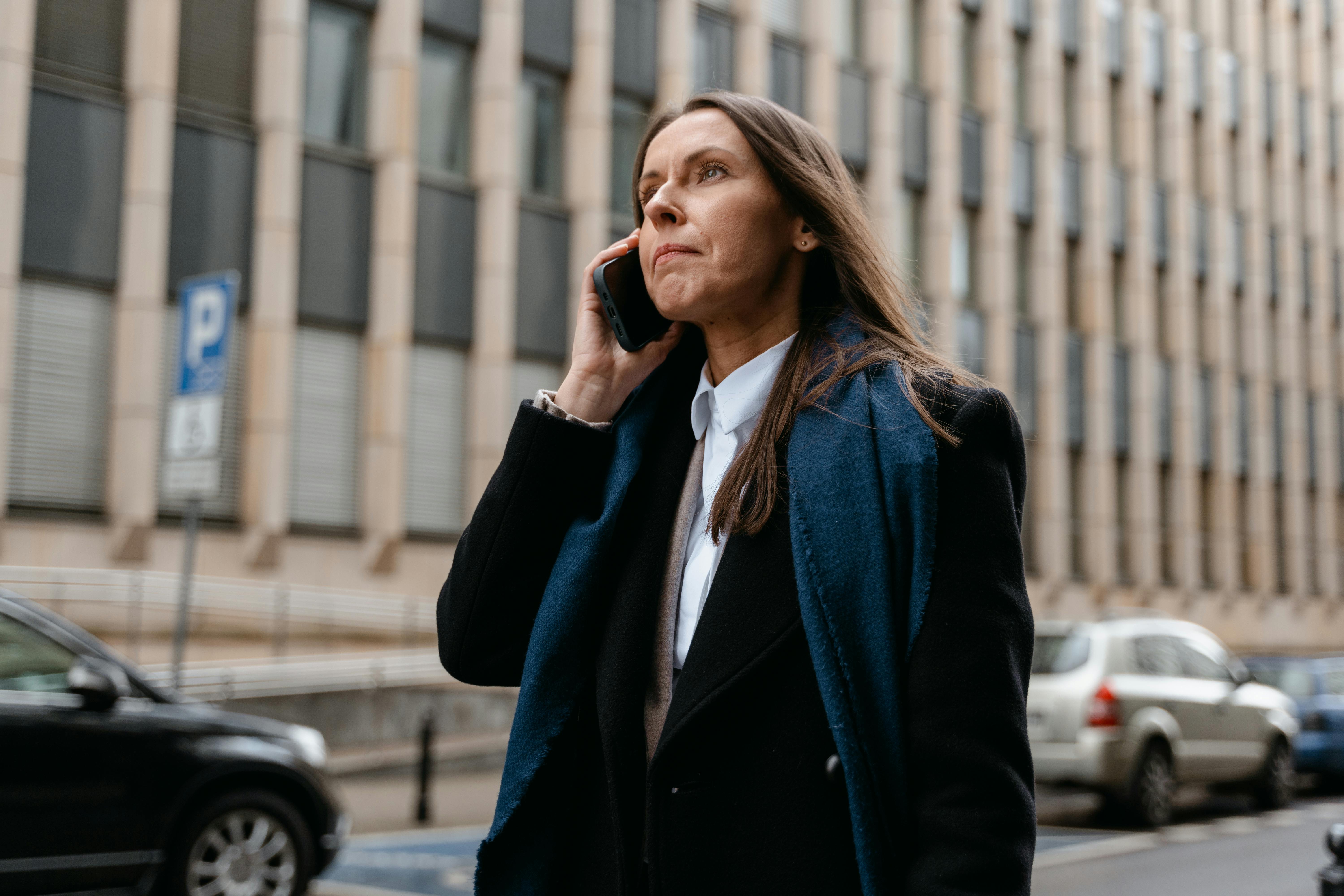 woman in black blazer standing near black car