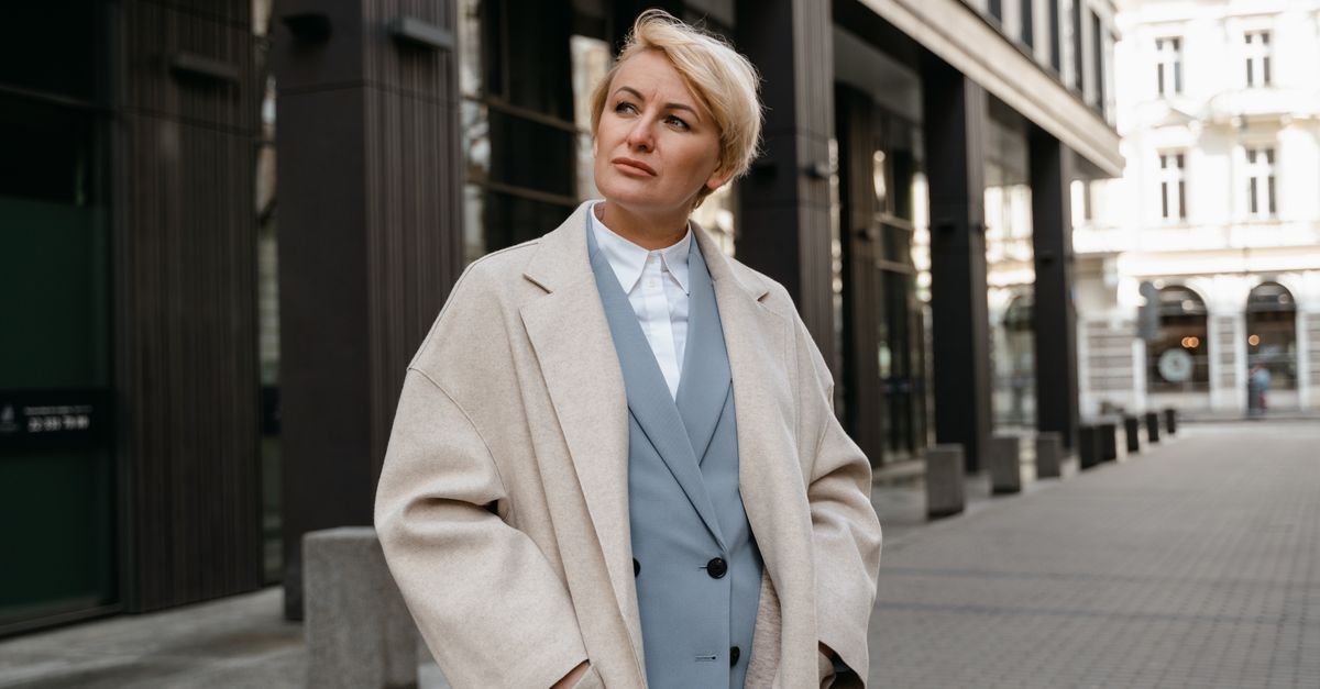 Woman in a statement coat over a classic suit