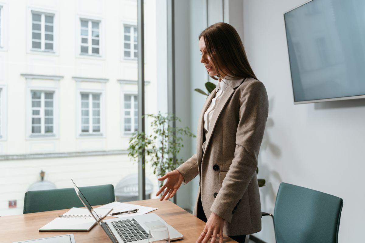 Professional working at a desk beside a large office window