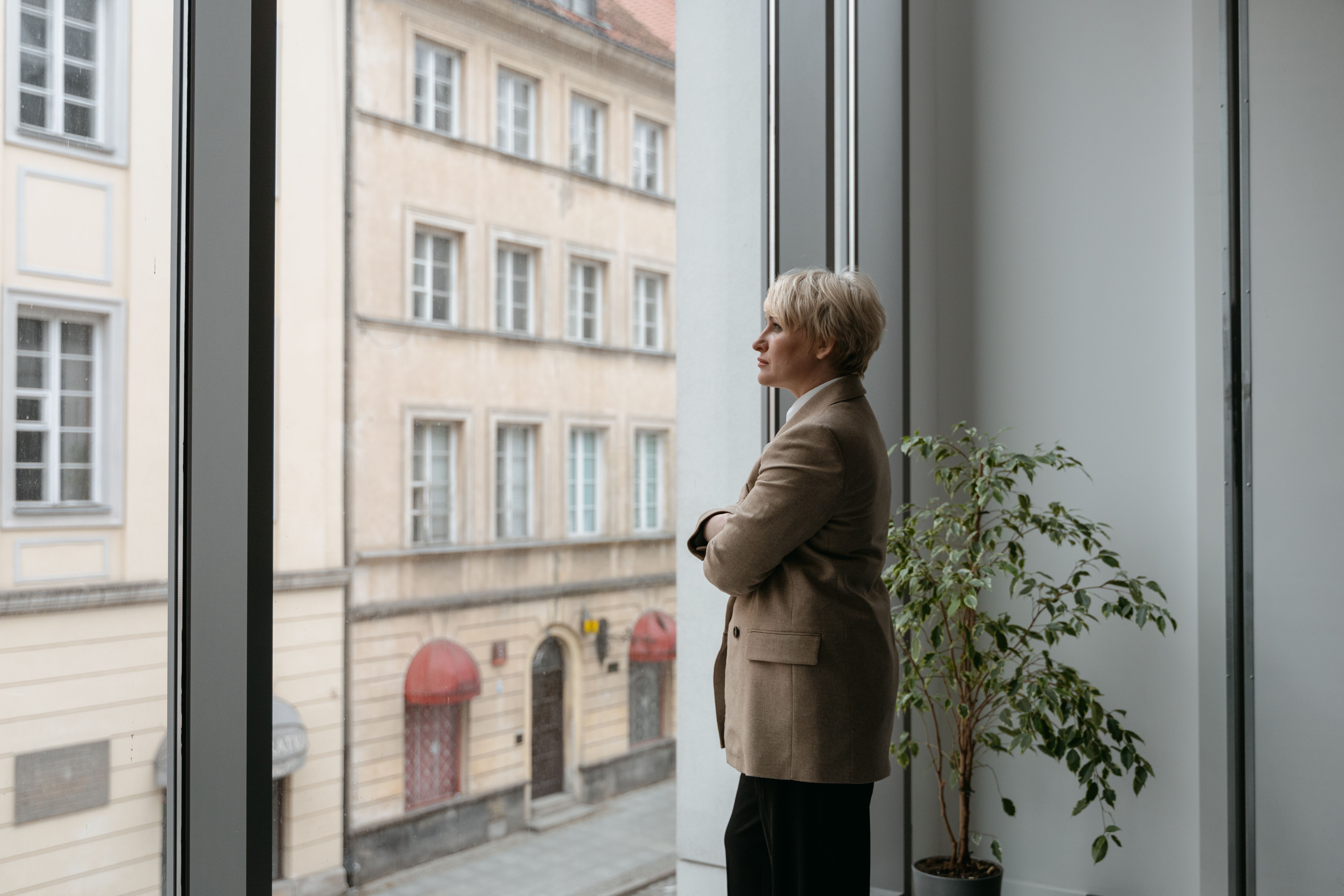 professional contemplating purpose looking out window office