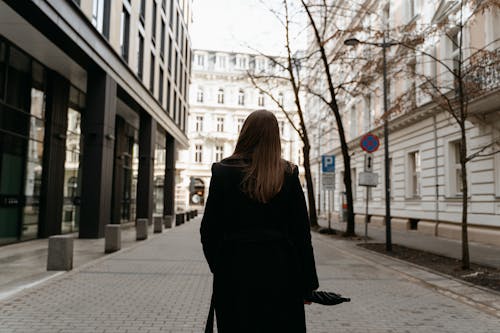 Back View of a Woman Walking Near Buildings