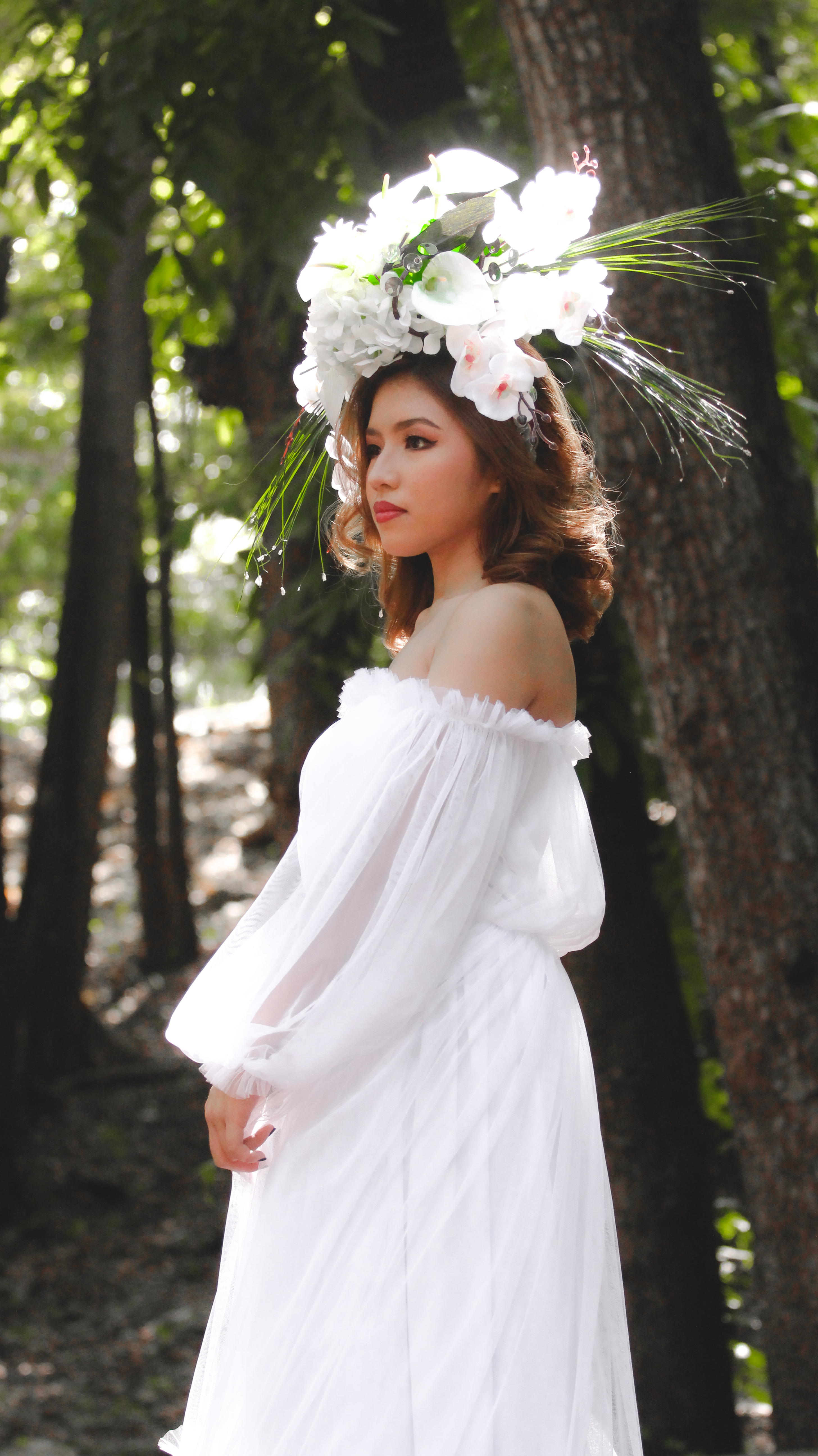 Woman Wearing a Long White Dress and a Huge Flower Crown in a Forest ...