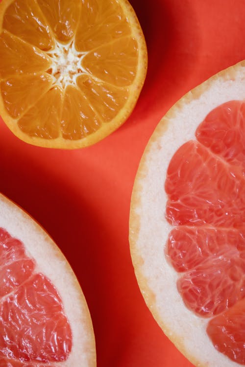 Sliced Citrus Fruits on Red Surface