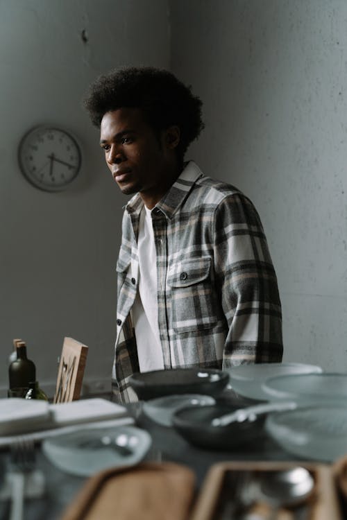 Man in Shirt Standing behind Table