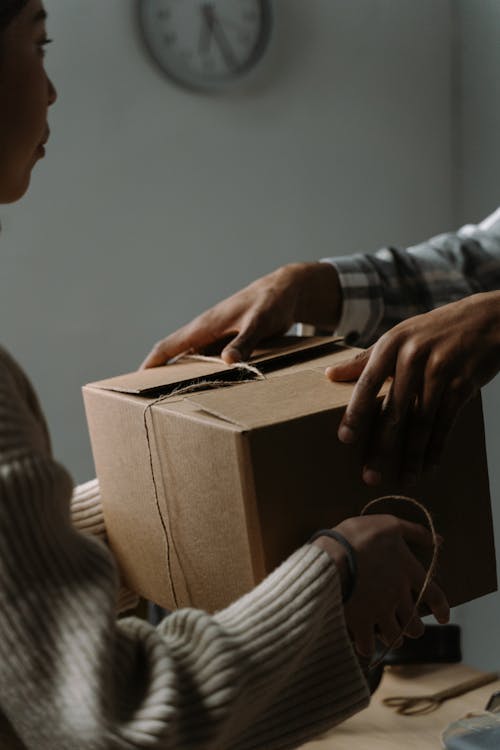 Man and Woman Holding Box