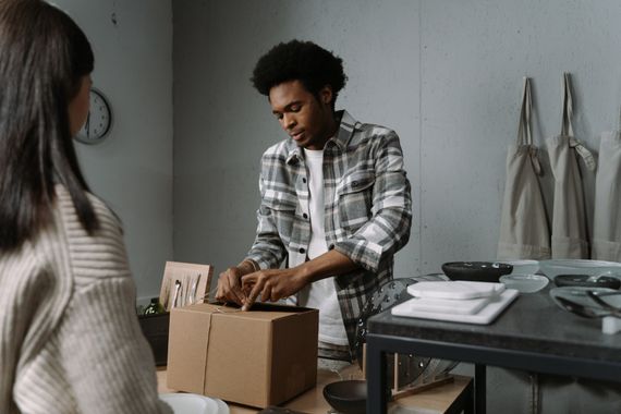 Home goods being carefully packed into a customer box