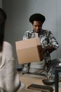 Man in Black and White Plaid Dress Shirt Holding Brown Cardboard Box