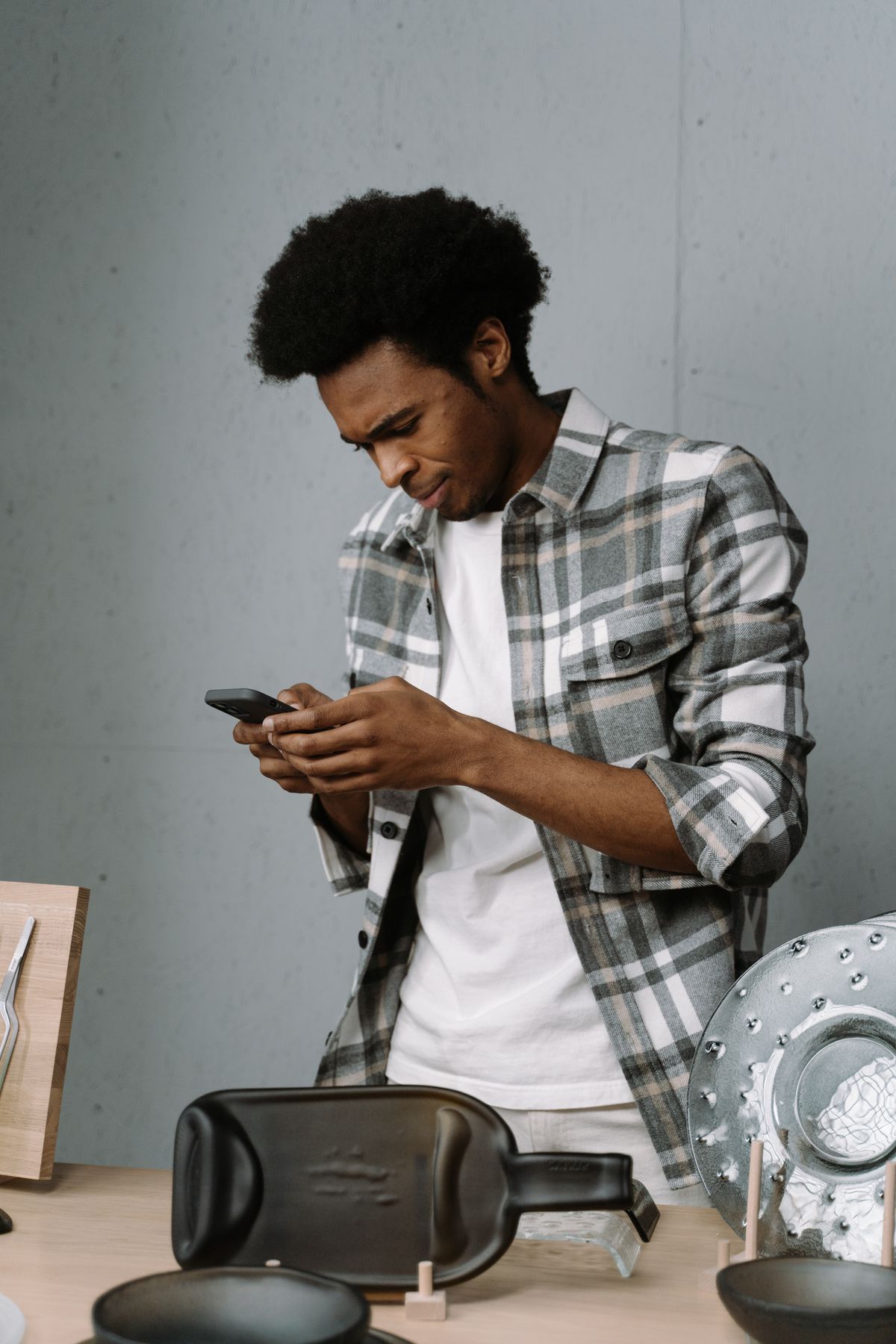 Man standing with a smartphone by a table